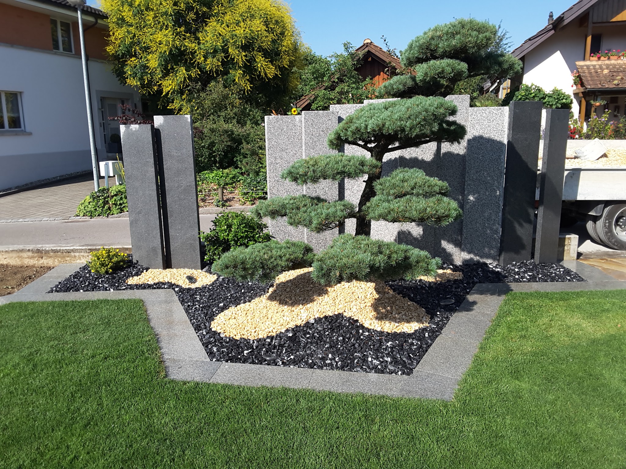 Gestalteter Vorgarten mit Bonsai-Kiefer, Granitstelen und Schiefersplitt