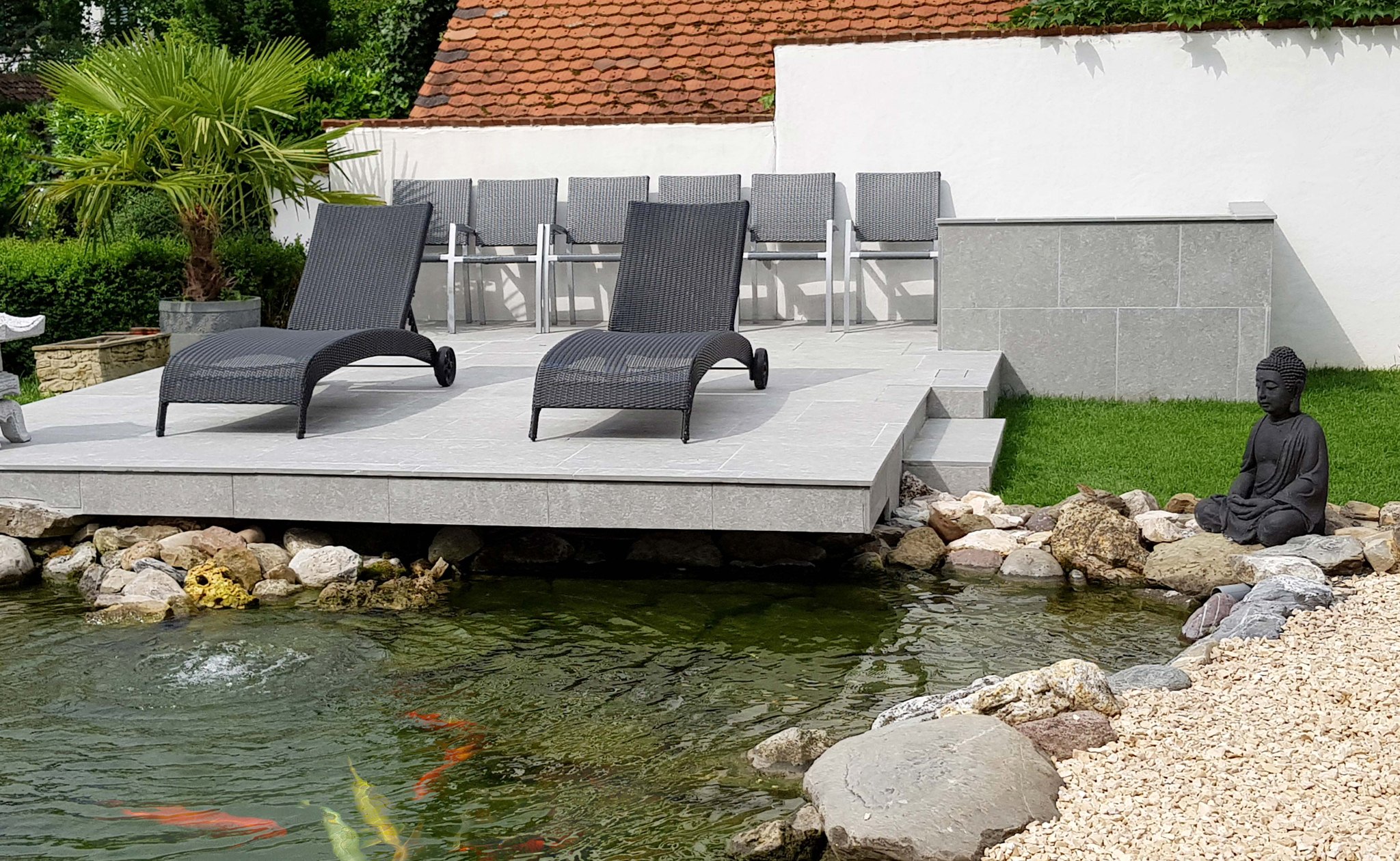 Teichanlage mit Holzdeck, Liegen und Natursteinmauer