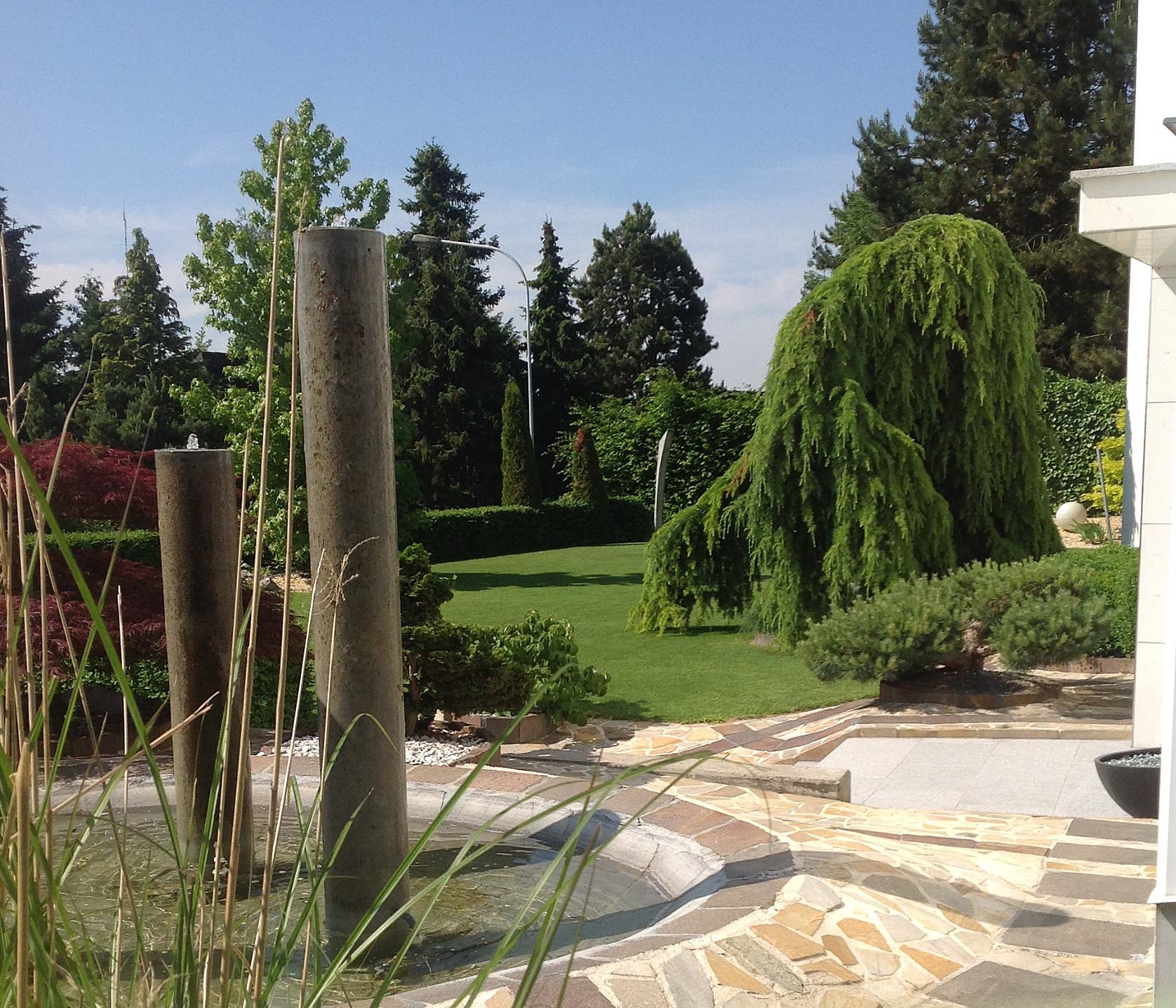 Garten mit Bäumen und Natursteinwegen