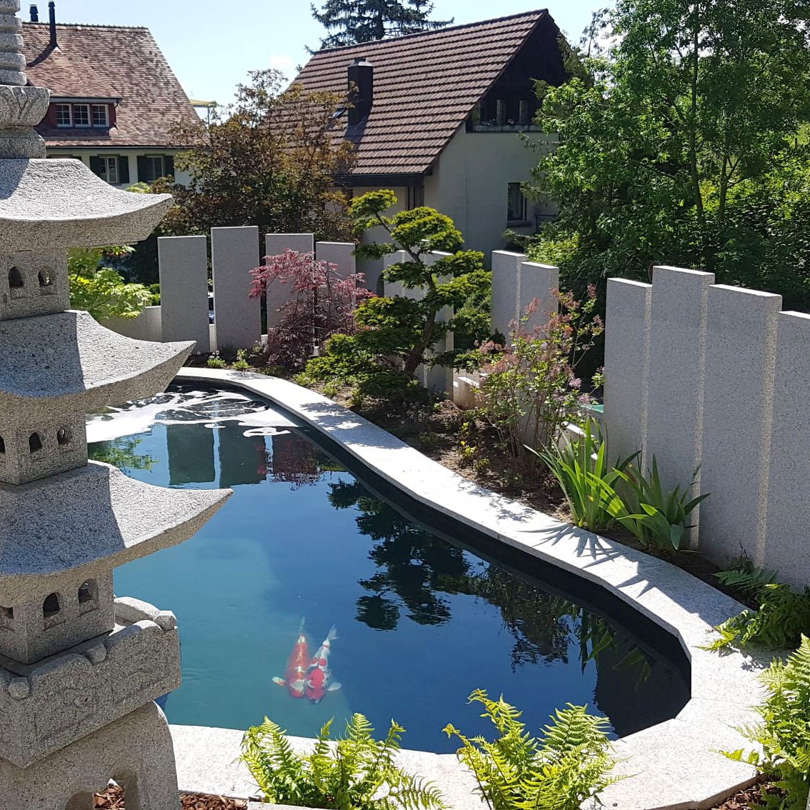 Teich mit Pagode zwischen Wohnhäusern